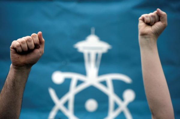 Volunteers hold their fists in the air during the March For Science in Seattle. REUTERS/David Ryder