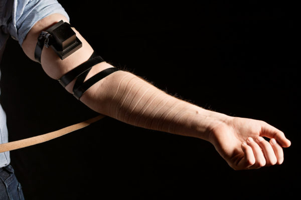 (photo: Elinor Carucci for The New York Times. caption: A Footsteps member removes his tefillin, a ritual object worn during prayers.)