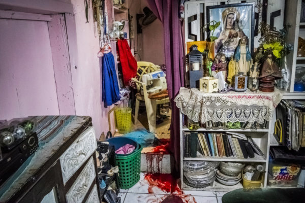 Daniel Berehulak for The New York Times. Caption 4: The blood of Florjohn Cruz, 34, stained the floor in his family’s living room, next to an altar displaying images and statues of the Virgin Mary, among other items.