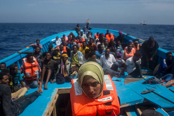 LAMPEDUSA, ITALY - MAY 24: Refugees and migrants are seen on board a wooden boat as they wait for rescue crews from the Migrant Offshore Aid Station (MOAS) 'Phoenix' vessel on May 24, 2017 off Lampedusa, Italy. The Migrant Offshore Aid Station (MOAS) 'Phoenix' vessel rescued 603 people after one of three wooden boats partially capsized leaving more than 30 people dead. Numbers of refugees and migrants attempting the dangerous central Mediterranean crossing from Libya to Italy has risen since the same time last year with more than 43,000 people recorded so far in 2017. In an attempt to slow the flow of migrants Italy recently signed a deal with Libya, Chad and Niger outlining a plan to increase border controls and add new reception centers in the African nations, which are key transit points for migrants heading to Italy. MOAS is a Malta based NGO dedicated to providing professional search-and-rescue assistance to refugees and migrants in distress at sea. Since the start of the year MOAS have rescued and assisted 3572 people and are currently patrolling and running rescue operations in international waters off the coast of Libya. (Photo by Chris McGrath/Getty Images)