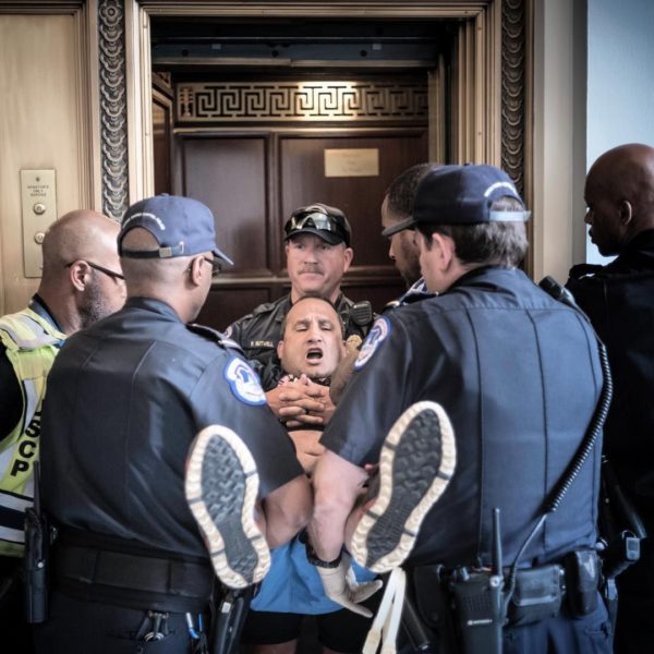 Photo: David Butow via Instagram Caption: A protester is carried into an elevator by Capitol police after a demonstration was staged at Mitch McConnell's office following release of the Senate Health Care bill. June 22, 2017