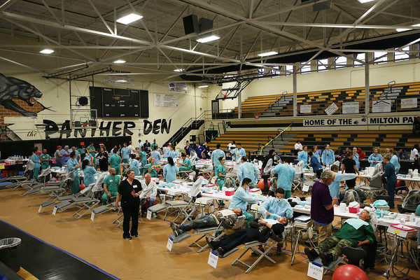 Dentists work on patients at the Remote Area Medical (RAM) mobile dental and medical clinic on December 3, 2016 in Milton, Florida. It is expected that over a thousand people will show up seeking free dental and medical care at the two-day event in the financially struggling Florida panhandle community. RAM provides free medical care through mobile clinics in underserved, isolated, or impoverished communities around the country and world. As health-care continues to be a contentious issue in America, an estimated 29 million Americans, about one in 10, lack coverage. Spencer Platt/Getty Images.