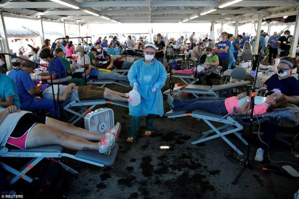 A volunteer walks past people receiving dental care at the Remote Area Medical Clinic in Wise, Virginia, U.S., July 22, 2017. Hundreds of Appalachia residents waited through the night for the annual Remote Area Medical (RAM), clinic for dental, vision and medical services held at the Wise County Fairgrounds in western Virginia. JOSHUA ROBERTS/REUTERS