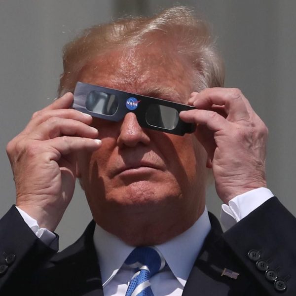 U.S.President Donald Trump puts on special glasses to look at the Solar Eclipse on the Truman Balcony at the White House on August 21, 2017 in Washington, DC. Millions of people have flocked to areas of the U.S. that are in the 'path of totality' in order to experience a total solar eclipse. (Photo by Mark Wilson/Getty Images)