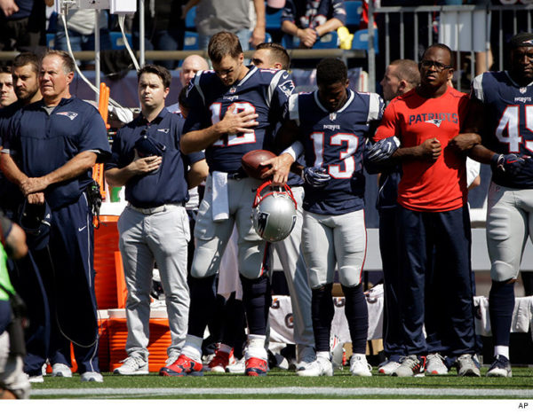 Tom Brady locked arms with a teammate during the national anthem before the game against the Houston Texans on Sunday. CreditSteven Senne/Associated Press