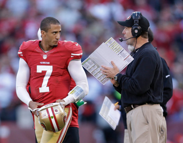 Kaepernick speaking with the 49ers’ head coach, Jim Harbaugh, during a game in 2012. MARCIO JOSE SANCHEZ / ASSOCIATED PRESS