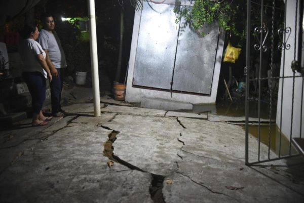 Angel Hernandez / European Photopress Agency/EFE. Caption: A couple looks at the damaged floor of their yard in Coatzacoalcos. September 8, 2017 