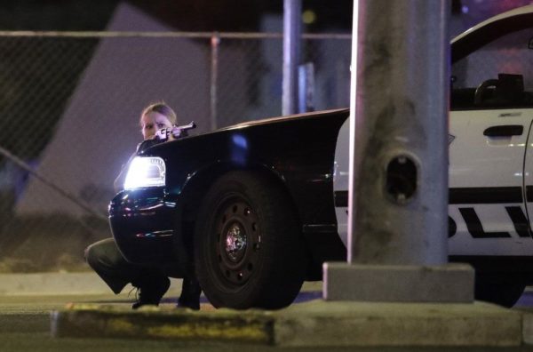 A police officer taking cover near the Mandalay Bay Resort and Casino on the Las Vegas Strip. Credit John Locher/Associated Press