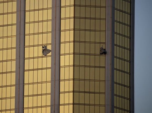 Drapes billow out of broken windows at the Mandalay Bay resort and casino Monday, Oct. 2, 2017, on the Las Vegas Strip following a deadly shooting at a music festival in Las Vegas. A gunman was found dead inside a hotel room. (AP Photo/John Locher)