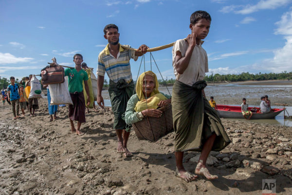 Rohingya Muslims, who crossed over from Myanmar into Bangladesh, carry an elderly woman in a basket and walk towards a refugee camp in Shah Porir Dwip, Bangladesh, Thursday, Sept. 14, 2017. Nearly three weeks into a mass exodus of (AP Photo/Dar Yasin)