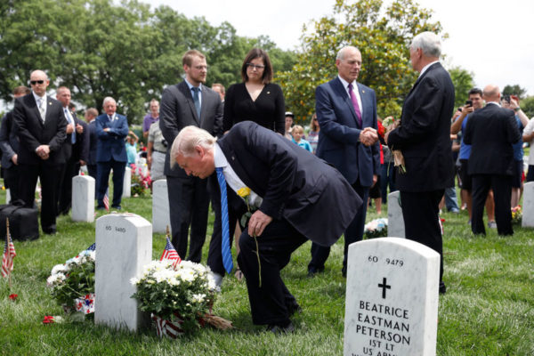Photo: Aaron P. Bernstein/Getty Images. Caption: As Vice President Mike Pence and Secretary of Homeland Security John Kelly shake hands, President Donald Trump lays flowers on the grave of Kelly's son Robert at Arlington National Cemetery on May 29, 2017 in Arlington, Virginia. Marine Lieutenant Robert Kelly was killed in 2010 while leading a patrol in Afghanistan.