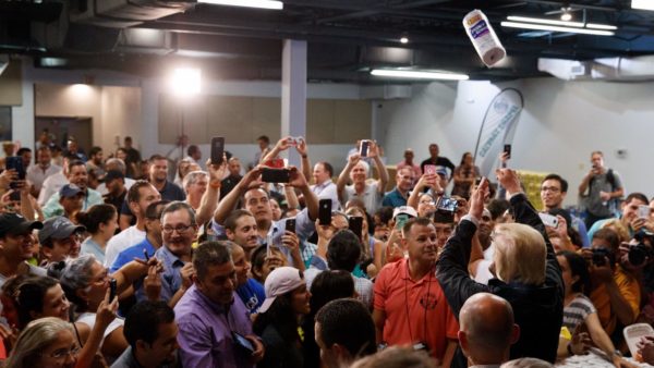Photo 2: Evan Vucci/AP Caption: President Donald Trump tosses paper towels into a crowd as he hands out supplies at Calvary Chapel on October 3, 2017, in Guaynabo, Puerto Rico