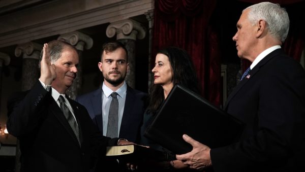 WASHINGTON, DC - JANUARY 03: U.S. Sen. Doug Jones (D-AL) (L) participates in a mock swearing-in ceremony with Vice President Mike Pence (R) as Jones' wife Louise (3rd L) and son Carson (2nd L) look on at the Old Senate Chamber of the U.S. Capitol January 3, 2018 in Washington, DC. Jones is the first Democratic senator from Alabama in more than two decades. He defeated Roy Moore leaving Republicans with a 51-49 majority in the U.S. Senate. (Photo by Alex Wong/Getty Images)