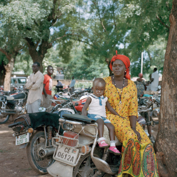 A mother and her daughter sit on a motorcycle while listening to a sermon outside of St. Joseph’s Catholic Church in Juba. Photo: Sarah Hylton for the New York Times