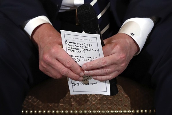 President Donald Trump holds notes during a listening session with high school students and teachers in the State Dining Room of the White House in Washington, Wednesday, Feb. 21, 2018. Trump heard the stories of students and parents affected by school shootings, following last week's deadly shooting in Florida. (AP Photo/Carolyn Kaster)