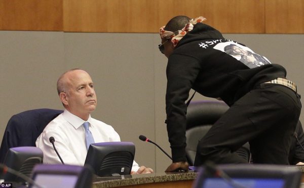 Photo: Rich Pedroncelli/AP Caption: Stevante Clark jumps on the dais and shouts at Sacramento Mayor Darrell Steinberg, left, during a city council meeting, Tuesday, March 27, 2018, in Sacramento, Calif. Clark, the brother of Stephon Clark, who was shot and killed by Sacramento Police officers a week earlier, disrupted the meeting and demanded to speak. The city council adjourned for a roughly 15-minute recess as a result of the disruption.