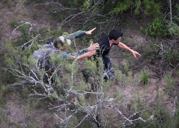 Photo: John Moore / Getty Images Caption: A United States Border Patrol agent pursuing a migrant near Falfurrias, Tex., in 2014