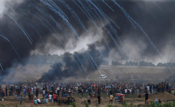 Tear gas canisters are fired by Israeli forces at Palestinian demonstrators during a protest demanding the right to return to their homeland, at the Israel-Gaza border, east of Gaza City, May 4, 2018.