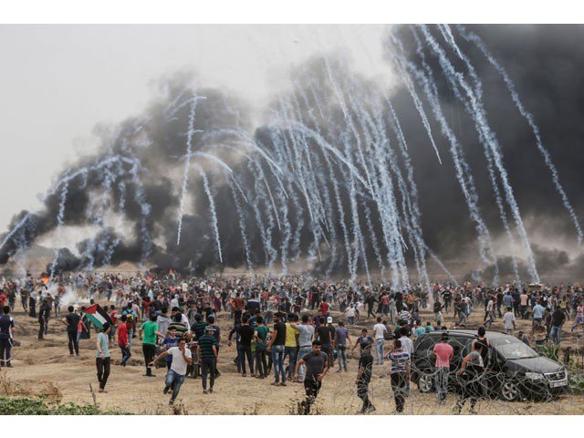 Palestinian protesters flee from incoming teargas canisters during clashes with Israeli forces along the border with the Gaza strip east of Gaza City on May 4, 2018, on the sixth straight Friday of mass demonstrations calling for the right to return to their historic homelands. PHOTO: AFP