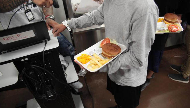 HHS Handout / Jacob Soboroff/Twitter. Accompanying Tweet: “Here are some photographs of the boys in the cafeteria. This is not a school cafeteria. Hundreds called to eat at a time on rotating shifts. When I told @chrislhayes it felt like a prison or jail, I was thinking about this.”