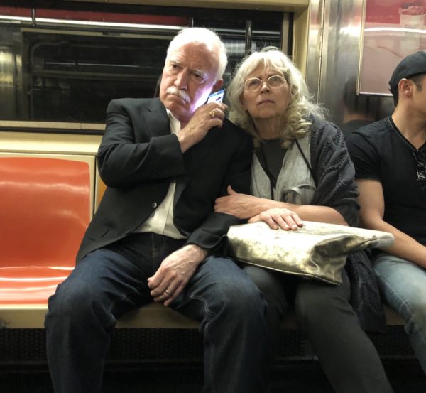 Couple listening to the Kavanaugh hearings on the uptown 1 train