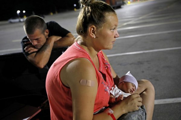 Lorrainda Smith sits with her 2-day-old son, Luke, on Oct. 15, 2018, as she contemplates with her husband, Wilmer Capps, right, sleeping in their truck in the parking lot of a Panama City, Fla., Walmart after their home was damaged from Hurricane Michael. (David Goldman/AP)