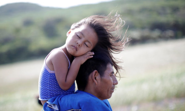 Rosendo Noviega, a 38-year-old migrant from Guatemala, part of a caravan of thousands from Central America en route to the United States, holds his daughter Belinda Izabel as he walks along the highway to Juchitan from Santiago Niltepec, Mexico, October 30, 2018. REUTERS/Ueslei Marcelino