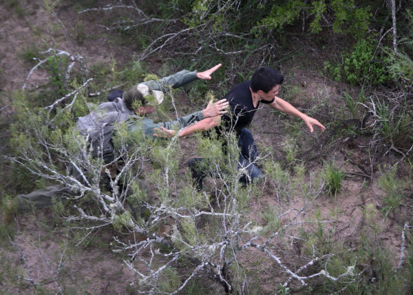 Photo by John Moore/Getty Images Caption: A U.S. Border Patrol agent tries to tackle an undocumented immigrant in dense underbrush on September 9, 2014 near Falfurrias, Texas. He missed but the immigrant was later caught by a fellow agent. Thousands of migrants continue to cross illegally from Mexico into the United States, and Texas' Rio Grande Valley has more traffic than any other sector of the U.S.-Mexico border.