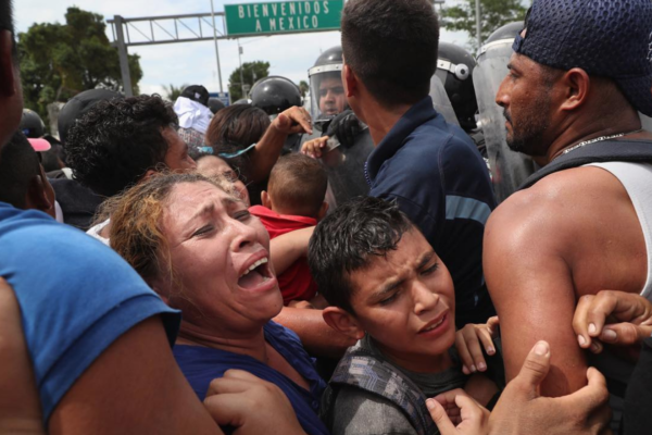 Photo: John Moore/ Getty Images Original Caption: Members of the migrant caravan are pushed forward into Mexican riot police on the border between Mexico and Guatemala on October 19, 2018 in Ciudad Tecun Uman, Guatemala. The clash occurred when the caravan of thousands of migrants tried to enter Mexico, crossing over the international bridge after pushing past Guatemalan security forces. The caravan tried to open the gate into Mexico but was pushed back by Mexican riot police. Some immigrants threw stones at police who then fired tear gas into the crowd.