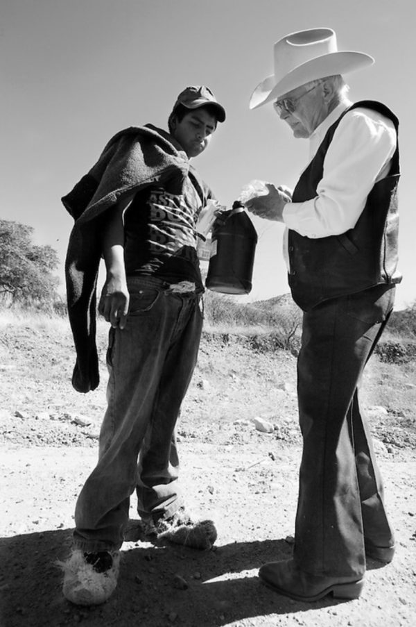 Photo: Nick Oza/Arizona Republic Caption: March 7, 2013. Rancher Jim Chilton offers water to Ivan Rebollar, 15, who said he’d been walking for two days without food or water since crossing the border. Chilton encountered Rebollar on Tres Bellotas Road, about eight miles north of the Mexico border. Rebollar, wearing carpet overshoes often used by drug smugglers, was walking south, towards Mexico, at the time. Rebollar, from a small town in Michoacan, Mexico, said he was looking for the Border Patrol to give himself up.