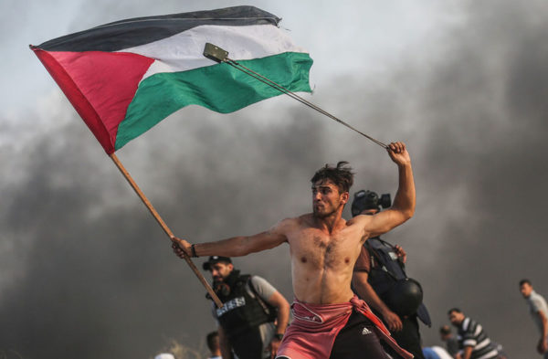 Palestinians burn tires and throw stones toward Israeli forces as they gather to support the maritime demonstration to break the Gaza sea blockade in Gaza City on October 22, 2018. (Mustafa Hassona / Anadolu Agency / Getty)