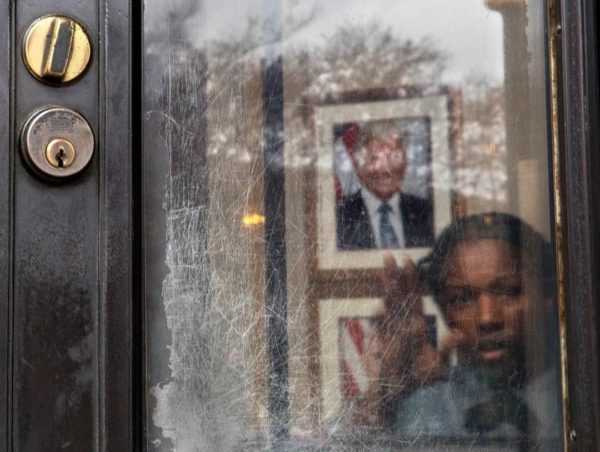 Photo by Evelyn Hockstein/For The Washington Post via Getty Images A security guard peers out of the visitors entrance door at the Environmental Protection Agency building, December 21, 2018, hours ahead of a possible partial government shutdown.