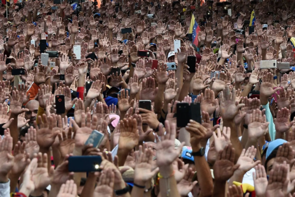 People raise their hands during a mass opposition rally against President Nicolás Maduro (Federico Parra/AFP/Getty Images)