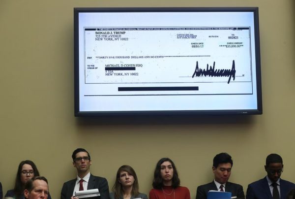 Photo: Jonathan Ernst/Reuters Caption: A $35,000 check signed by President Donald Trump to Michael Cohen is shown on a television monitor inside the hearing room.