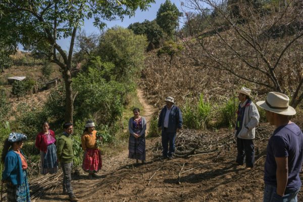 Photo 3: Mauricio Lima. Caption: Sebastian Charchalac talks to villagers in a field in Paraje León. Trained agronomists, through grants, have been instructing rural communities in diversifying crops, conserving water, and reforesting some of the surrounding areas.