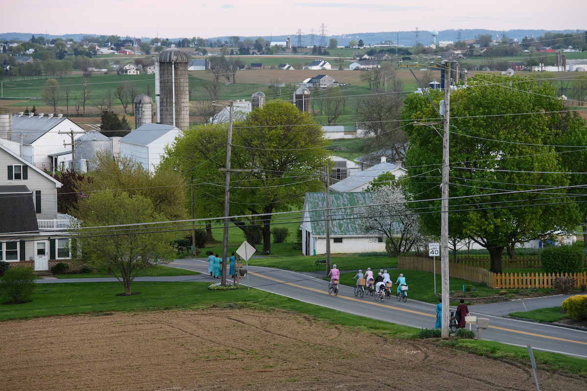 Women ride their bicycles through farms and homes along South Fairmount Road, Sunday, April 21, 2019, in Ephrata, Lancaster County. (Stephanie Strasburg/Post-Gazette)