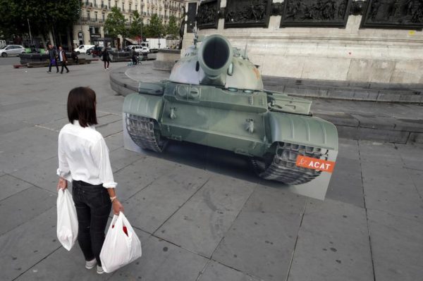 PHOTO: Philippe Wojazer/REUTERS Caption: A member of the Worldwide Human Rights Movement poses in front of a mock tank on the Place de la Republique in Paris, France, June 4, 2019.