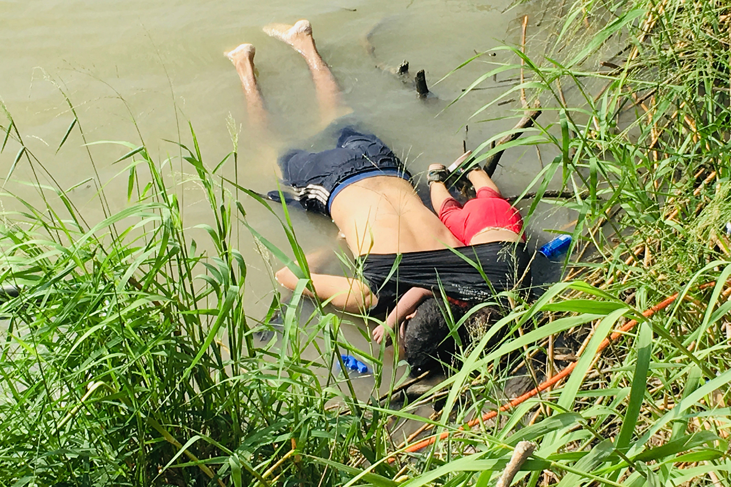 ADDS THAT PHOTO WAS FIRST PUBLISHED IN MEXICAN NEWSPAPER LA JORNADA - EDS NOTE: GRAPHIC CONTENT - The bodies of Salvadoran migrant Oscar Alberto Martínez Ramírez and his nearly 2-year-old daughter Valeria lie on the bank of the Rio Grande in Matamoros, Mexico, Monday, June 24, 2019, after they drowned trying to cross the river to Brownsville, Texas. Martinez' wife, Tania told Mexican authorities she watched her husband and child disappear in the strong current. This photograph was first published in the Mexican newspaper La Jornada. (AP Photo/Julia Le Duc)