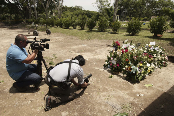Members of the press take images of the grave of Oscar Alberto Martinez and his almost two-year-old daughter Valeria after their burial at the Municipal Cemetery of La Bermeja in San Salvador, El Salvador, Monday, July 1, 2019. The bodies of the father and daughter migrants who drowned together trying to cross the Rio Grande into Texas on June 23 were laid to rest in their native El Salvador. Salvador Melendez—AP