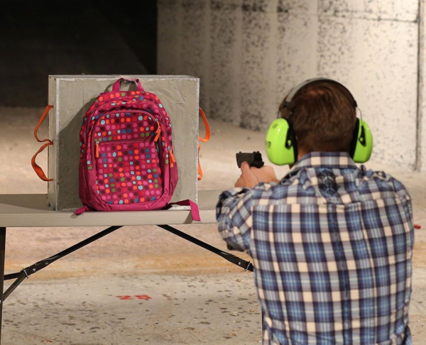 Photo by George Frey/Getty Images file Chief Operating Officer for Amendment II, Rich Brand, shoots a child's backpack with their Rynohide CNT Shield in it on December 21, 2012 in Salt Lake City, Utah. Their orders for the bulletproof shield have gone up dramatically since the school shooting in Connecticut last week.