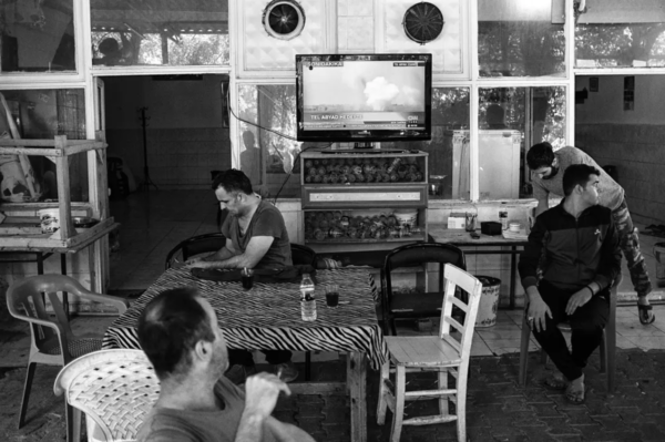 Photo: Emin Ozmen / Magnum Photos. People in Akçakale watch television reports on the bombing of Tel Abyad, the city across the Turkish border, on the second day of Turkish military operations against Kurdish fighters.