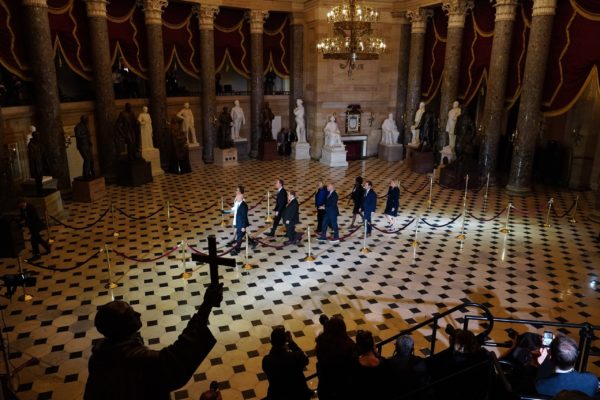 Photo: David Burnett/Contact Press Images. Cheryl L. Johnson, the clerk of the House of Representatives, and Paul D. Irving, the House’s sergeant-at-arms, lead a procession with the two articles of impeachment against President Trump through National Statuary Hall on the way to the Senate chamber, on Thursday.