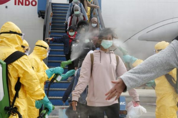 Photo: Antara Foto/via REUTERS Medical officers spray Indonesian nationals with antiseptic after they arrived from Wuhan, China, before transferring them to be quarantined, at Hang Nadim Airport in Batam, Indonesia, February 2.