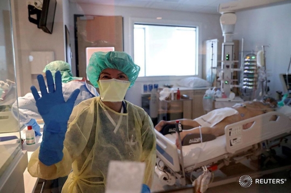 SENSITIVE MATERIAL. THIS IMAGE MAY OFFEND OR DISTURB A member of the medical personnel gestures as patients suffering from coronavirus disease (COVID-19) are treated at the intensive care unit at MontLegia CHC clinic in Liege, Belgium, March 26, 2020. REUTERS/Yves Herman