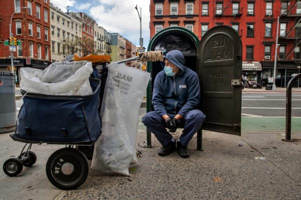 A postal worker in the East Village neighborhood of Manhattan.Credit...Brittainy Newman/The New York Times