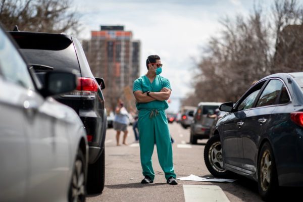 Health care workers stand in the street in counter-protest to hundreds of people who gathered at the State Capitol to demand the stay-at-home order be lifted in Denver, Colorado, April 19, 2020. Photo: Alyson McClaran