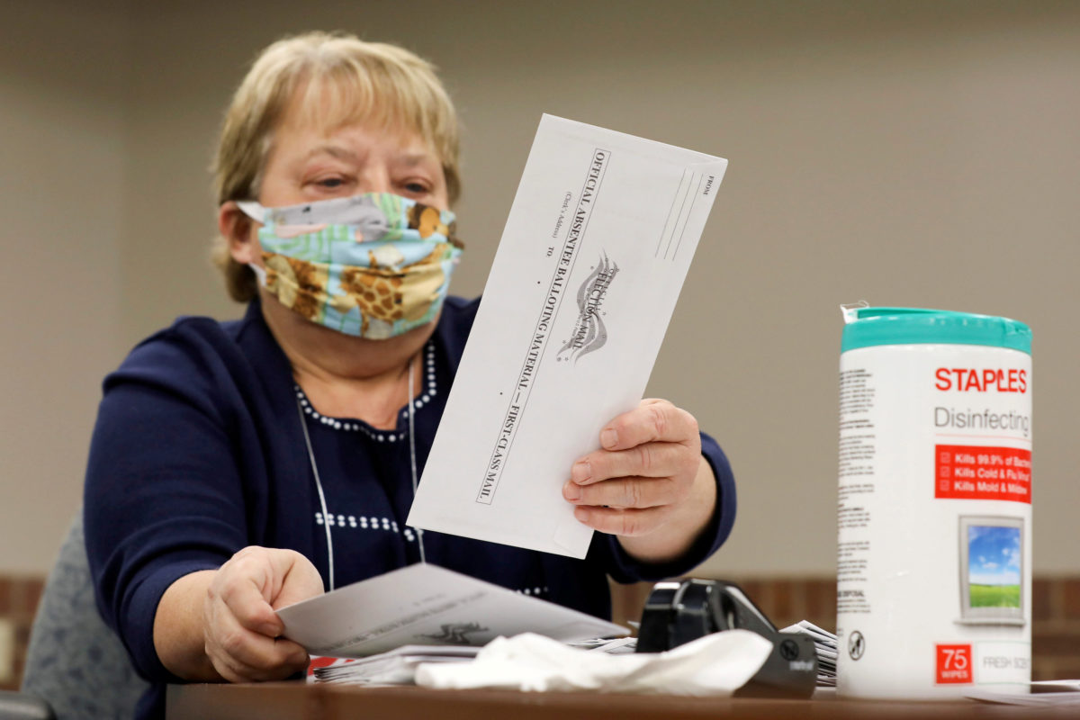 Election volunteer Nancy Gavney verifies voter and witness signatures on absentee ballots as they are counted at the City Hall during the presidential primary election held amid the coronavirus disease (COVID-19) outbreak in Beloit, Wisconsin, U.S. April 7, 2020. REUTERS/Daniel Acker TPX IMAGES OF THE DAY