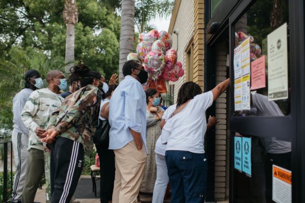 Photo: Isadora Kosofsky Caption:The Botiz family reacted to seeing Beatrice Botiz, 82, through the doorway at Alexandria Care Center in Los Angeles on Sunday, May 10.