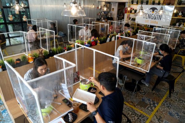 photo by Athit Perawongmetha for Reuters. People have lunch at the Penguin Eat Shabu hotpot restaurant after it reopened in Bangkok, Thailand, May 8.