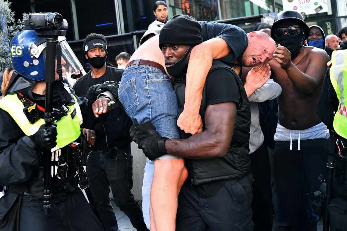 Protester Patrick Hutchinson carries an injured counter-protester to safety, near the Waterloo station during a Black Lives Matter protest following the death of George Floyd in Minneapolis police custody, in London, Britain, June 13, 2020. REUTERS/Dylan Martinez